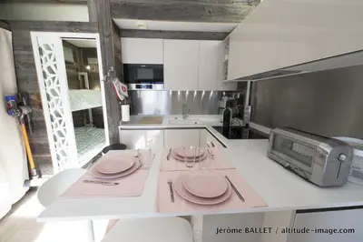 a kitchen with a table with plates and a microwave at NID DOUILLET DE FLAINE in Flaine