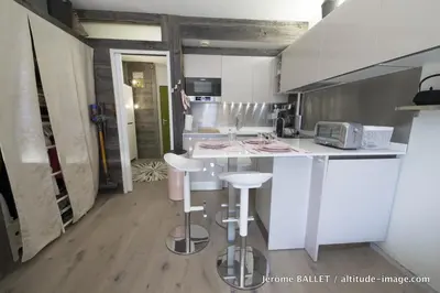 a kitchen with a white counter and stools in it at NID DOUILLET DE FLAINE in Flaine