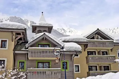 a large building with snow on top of it at Résidence La Ginabelle - maeva Home - Appartement 4 Pièces 8 Personnes - Sélection MAE-7444 in Chamonix-Mont-Blanc