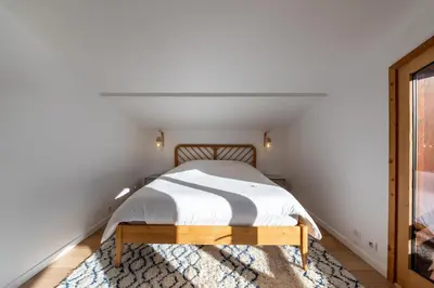 a bedroom with a bed and a rug at Le Relief - Maison avec magnifique vue montagne aux Bettex in Saint-Gervais-les-Bains