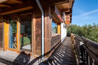 a wooden balcony of a house with windows at Le Relief - Maison avec magnifique vue montagne aux Bettex in Saint-Gervais-les-Bains