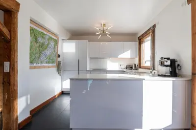 a kitchen with white cabinets and a counter top at Le Relief - Maison avec magnifique vue montagne aux Bettex in Saint-Gervais-les-Bains