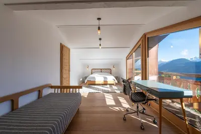 a bedroom with a bed and a desk and a view at Le Relief - Maison avec magnifique vue montagne aux Bettex in Saint-Gervais-les-Bains