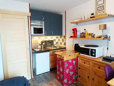 a kitchen with blue cabinets and a microwave on a counter at Les Hauts De Saint Gervais in Saint-Gervais-les-Bains