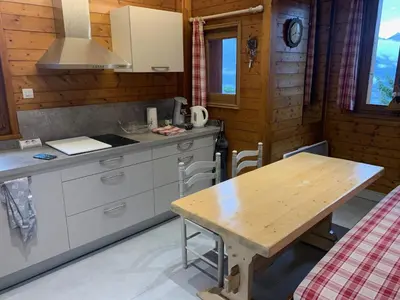 a kitchen with a wooden table in a cabin at LES TOURISTES in Combloux
