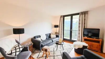 a living room with couches and a flat screen tv at Résidence Verseau - Appartement lumineux et spacieux · Centre station · avec cabine et Balcon MAE-8894 in Magland