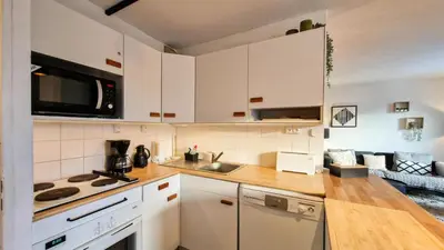 a kitchen with white cabinets and a counter top at Résidence Verseau - Appartement lumineux et spacieux · Centre station · avec cabine et Balcon MAE-8894 in Magland