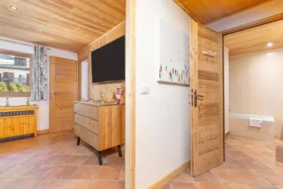 a room with a television and a wooden door at Résidence Les Arcades du Mont-Blanc in Megève