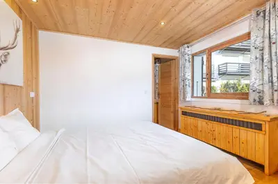 a bedroom with a white bed and a window at Résidence Les Arcades du Mont-Blanc in Megève