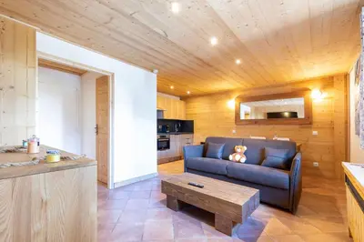 a living room with a blue couch and a table at Résidence Les Arcades du Mont-Blanc in Megève