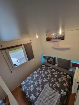 a small room with a bed and a window at Charmant mobilhome à 2 pas remontés ski Samoëns in Samoëns