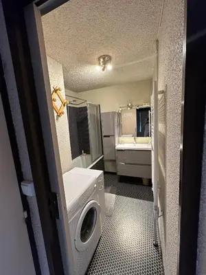 a bathroom with a sink and a washing machine at Arve et Giffre Samoens 1600 in Samoëns