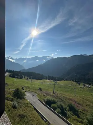 a road in a field with the sun in the sky at Arve et Giffre Samoens 1600 in Samoëns