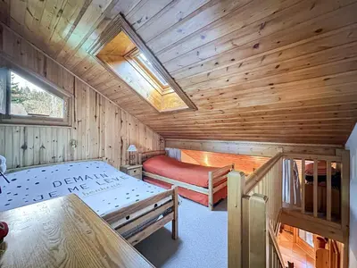 a room with two beds in a wooden cabin at luta11 duplex mezzanine 2 4 pers pied de pistes in Les Carroz d'Araches