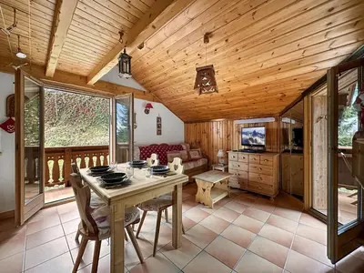 a dining room with a table and a couch at luta11 duplex mezzanine 2 4 pers pied de pistes in Les Carroz d'Araches