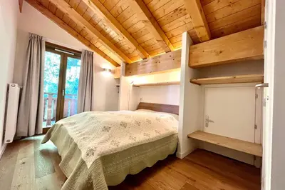 a bedroom with a bed in a room with wooden ceilings at Flocon du Medonnet in Combloux