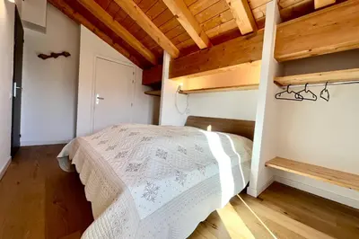 a bedroom with a white bed in a room with wooden ceilings at Flocon du Medonnet in Combloux