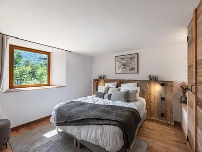 a living room with a red couch and wooden ceilings at Chalet convivial à proximité des pistes avec balcon et WIFI - FR-1-663-23 in Saint-Gervais-les-Bains