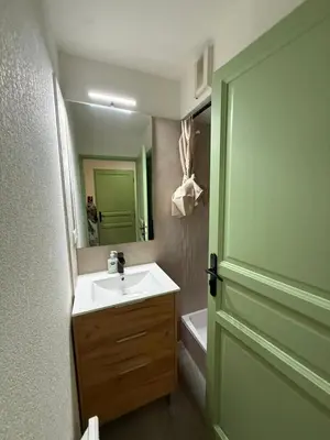 a bathroom with a sink and a mirror and a door at Be first on the lift each morning! 2bed apt. 6 pax in Saint-Gervais-les-Bains