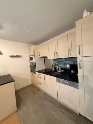 a kitchen with white cabinets and black counter tops at Be first on the lift each morning! 2bed apt. 6 pax in Saint-Gervais-les-Bains