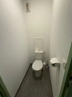 a small white bathroom with a toilet and a mirror at Be first on the lift each morning! 2bed apt. 6 pax in Saint-Gervais-les-Bains