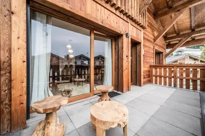 a porch with two stools and a window at Apartment Centaurea Megève - BY EMERALD STAY in Megève
