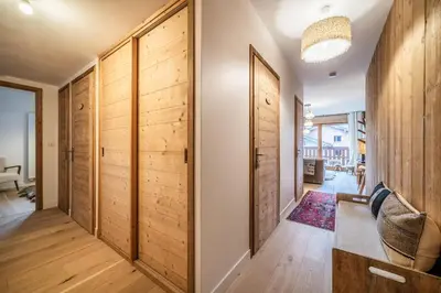 a hallway with wood paneling and a hallway with a door at Apartment Centaurea Megève - BY EMERALD STAY in Megève