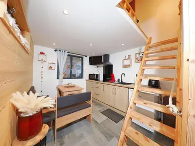 a kitchen with a staircase in a tiny house at Le Nid Cosy in Passy