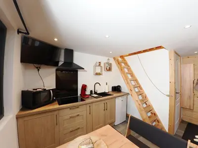 a kitchen with a wooden counter and a ladder at Le Nid Cosy in Passy