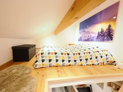a bedroom with a bed and a painting on the wall at Le Nid Cosy in Passy