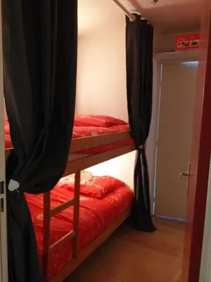 a bedroom with two bunk beds with black curtains at Studio 4 couchages 