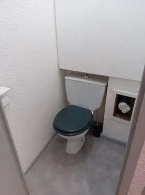 a bathroom with a toilet with a green lid at Studio 4 couchages 