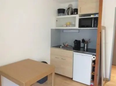 a small kitchen with a counter and a table at Studio 4 couchages 