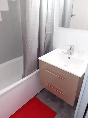 a white bathroom with a sink and a shower at Studio 4 couchages 