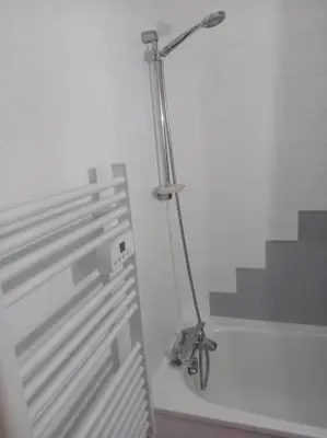 a bathroom with a shower with a light on the wall at Studio 4 couchages 