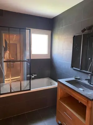 a bathroom with a bath tub and a sink at Appartement Au pied du Jaillet in Megève