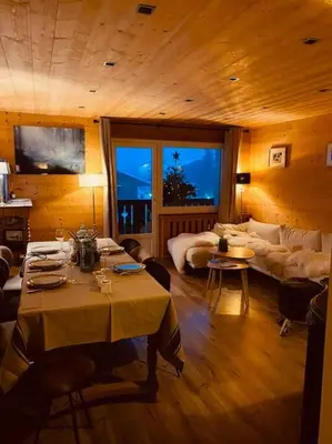 a living room with a table and a couch at Appartement Au pied du Jaillet in Megève