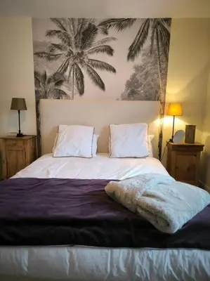 a bedroom with a large bed with a palm tree mural at Appartement Au pied du Jaillet in Megève