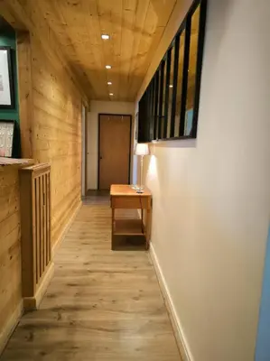 a hallway with a table and a lamp on a desk at Appartement Au pied du Jaillet in Megève