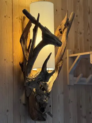 a light hanging on a wall with a piece of driftwood at Cocon au cœur de Chamonix avec parking gratuit in Chamonix-Mont-Blanc