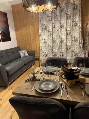 a dining room with a table and a couch at Cocon au cœur de Chamonix avec parking gratuit in Chamonix-Mont-Blanc