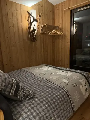 a bedroom with a bed and a wall at Cocon au cœur de Chamonix avec parking gratuit in Chamonix-Mont-Blanc
