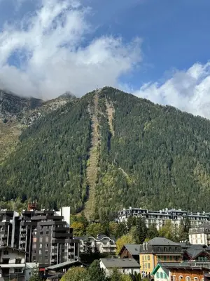 a view of a mountain with a city and buildings at Cocon au cœur de Chamonix avec parking gratuit in Chamonix-Mont-Blanc