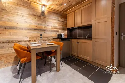 a kitchen with wooden walls and a table and chairs at 