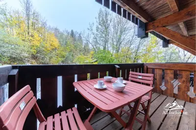 a wooden table and two chairs on a deck at 