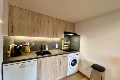 a kitchen with a washing machine and a washer at Le Doux Sapin in Saint-Gervais-les-Bains