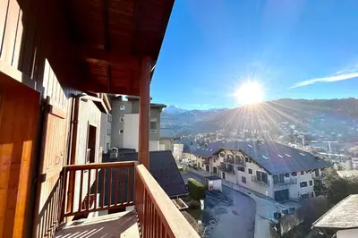 a view of the sun from a balcony of a building at Le Doux Sapin in Saint-Gervais-les-Bains