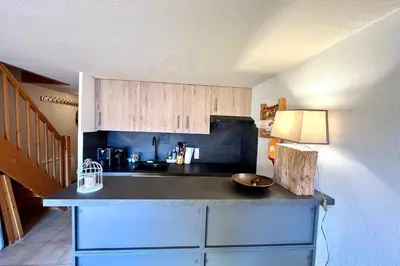 a kitchen with a black counter top in a room at Le Doux Sapin in Saint-Gervais-les-Bains