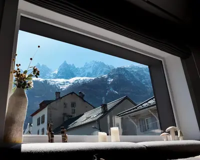 a bedroom with a bed and a desk in a room at Chalet hôtel le Whymper in Chamonix-Mont-Blanc