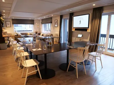 a dining room with a large table and chairs at Chalet hôtel le Whymper in Chamonix-Mont-Blanc